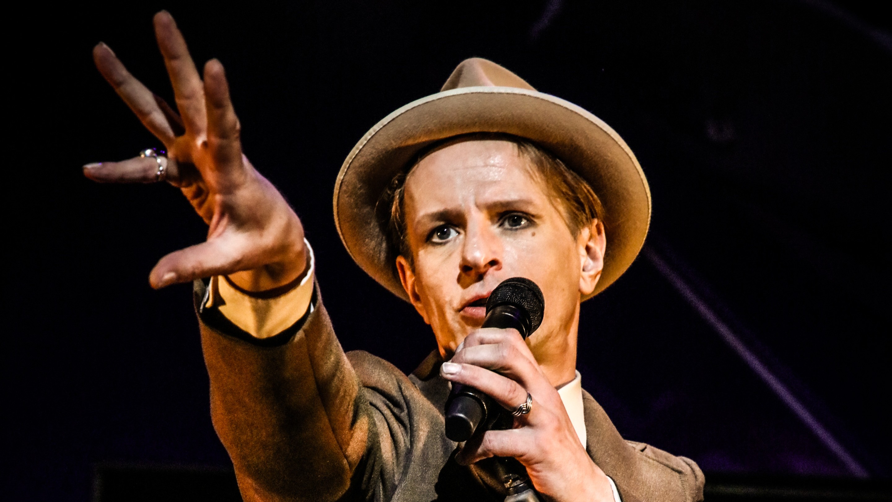 Alexander Scheer mit Hut singend am Mikrofon