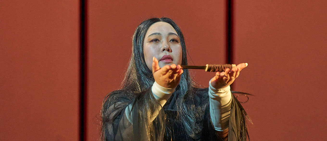 Szenenfoto aus der Oper "Madama Butterfly": Die japanische Geisha Cio©Cio©San hält einen Dolch auf ihren ausgestreckten Händen.