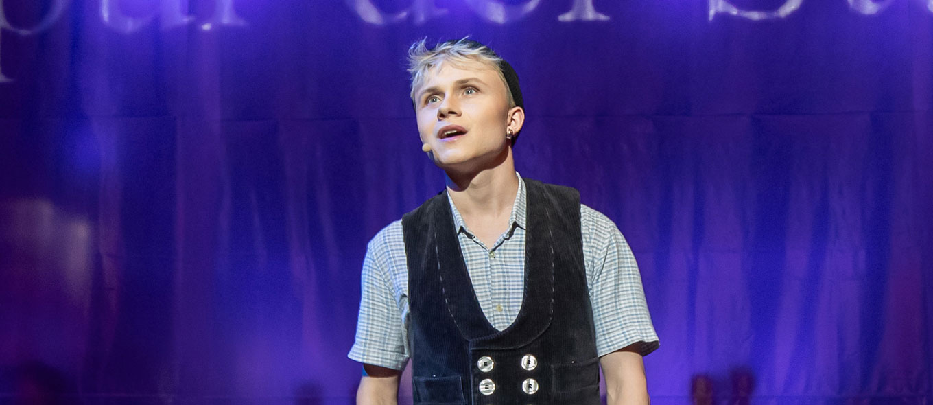 Szenenfoto aus "Spur der Steine", Schauspiel mit Musik: Ein junger Mann in Zimmermannskluft singt.